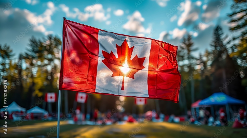 Vibrant Canadian flag flutters in focus against a blurred festival backdrop, embodying national pride during a sunny outdoor gathering.n culture. - obrazy, fototapety, plakaty 