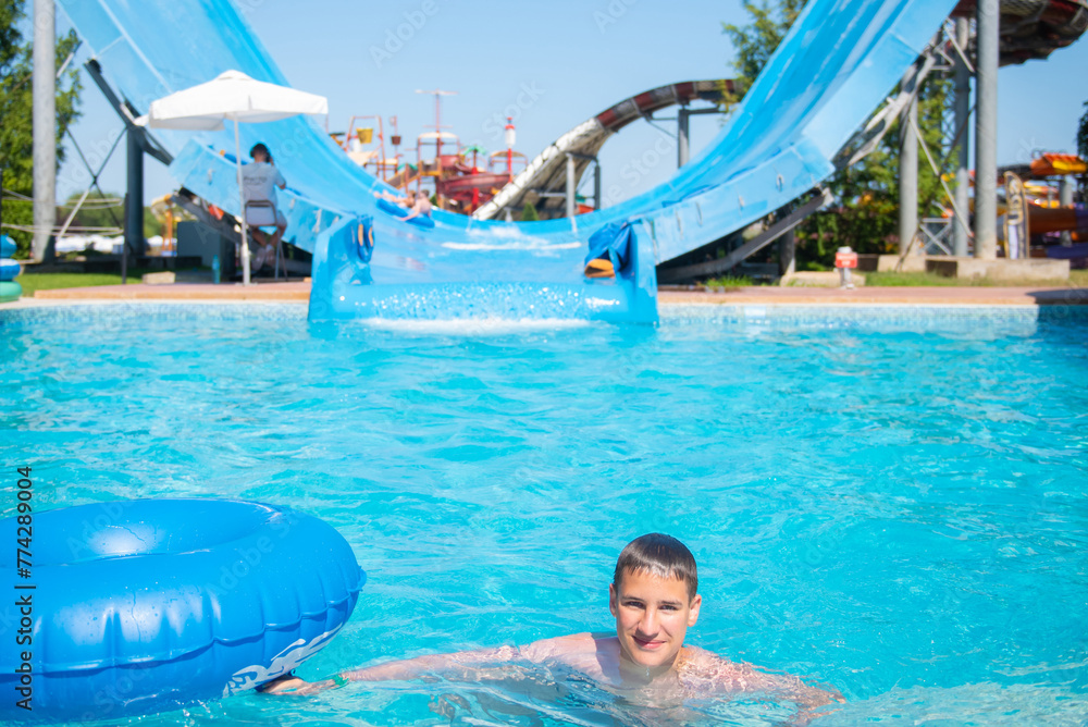 Teenager with inflatable ring in the pool of the Water Park.