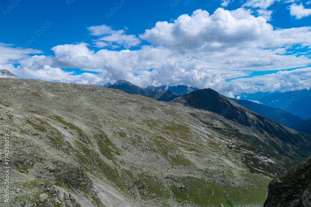 Rough alpine terrain with panoramic view of majestic mountain peak ridges in High Tauern National Park, Carinthia, Austria. Idyllic hiking trail over rocky scree field in summer. Remote Austrian Alps