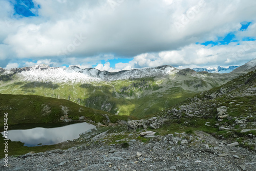 Idyllic alpine lake with panoramic view of majestic snow capped mountain peak Mallnitzriegel, High Tauern National Park, Carinthia, Austria. Wanderlust in Austrian Alps. Nature escape. Extreme terrain photo