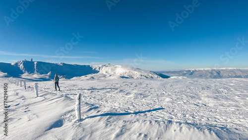 Woman in snowshoes on the way to majestic summit peak Grosser Speikogel in Kor Alps, Lavanttal Alps, Carinthia Styria, Austria. Winter wonderland in Austrian Alps. Idyllic ski touring hiking trail © Chris
