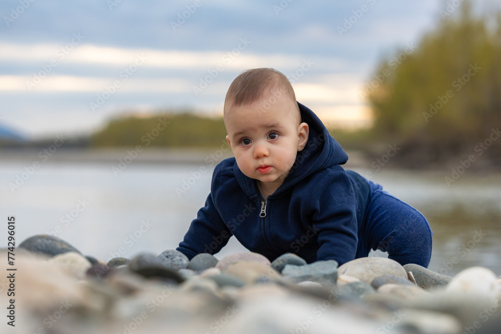 Caucasian Baby Boy playing outside with rocks by river. Caucasian Baby Boy playing outside with rocks by river.