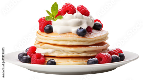 A stack of pancakes topped with whipped cream and fresh berries
