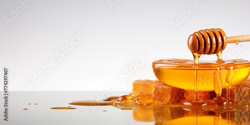 Liquid honey background, banner with wooden dipper and honeycombs on white background with copy space © alstanova@gmail.com