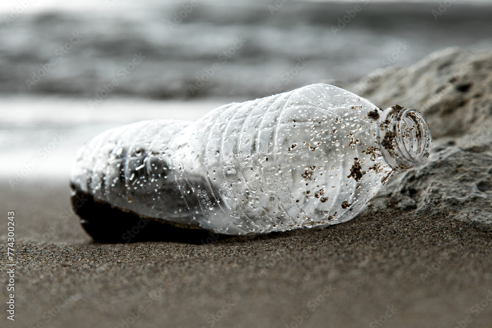 A Plastic water bottle waste washed up on the beach pollution - obrazy, fototapety, plakaty 