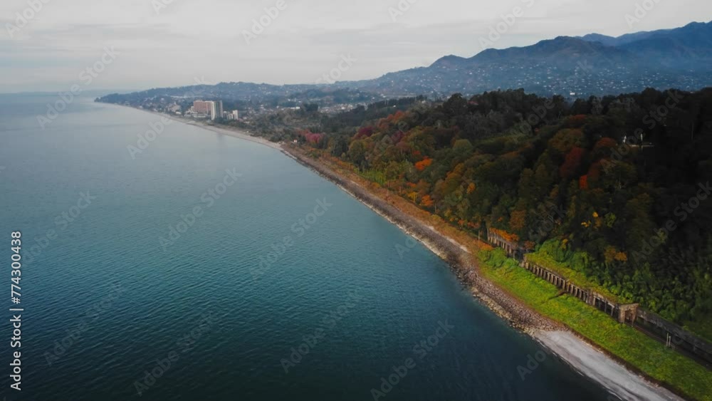 Drone scenery of long shore of the Black Sea in Georgia where Botanical garden is located. Coastline washed by calm water and the city with mountains on the background at warm autumn day in Batumi Drone scenery of long shore of the Black Sea in Georgia where Botanical garden is located. Coastline washed by calm water and the city with mountains on the background at warm autumn day in Batumi