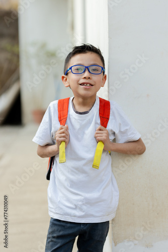 Hispanic boy with his backpack ready to go to school - boy with backpack outside his school in the rural area - Latin American boy