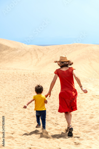 Mother and son tourists enjoying running in the dunes of Maspalomas  Gran Canaria  Canary Islands