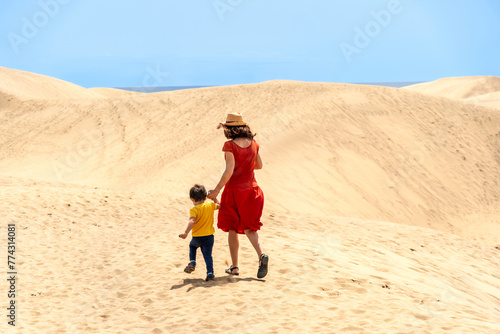 Mother and son on vacation walking in the dunes of Maspalomas, Gran Canaria, Canary Islands