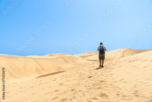 A tourist walking through the dunes of Maspalomas, Gran Canaria, Canary Islands