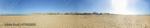 Wide panoramic photo taken in Agadir in Morocco showing the beach front and the mountains with the monument in the hill known locally as Dieu la Patrie Le Roi