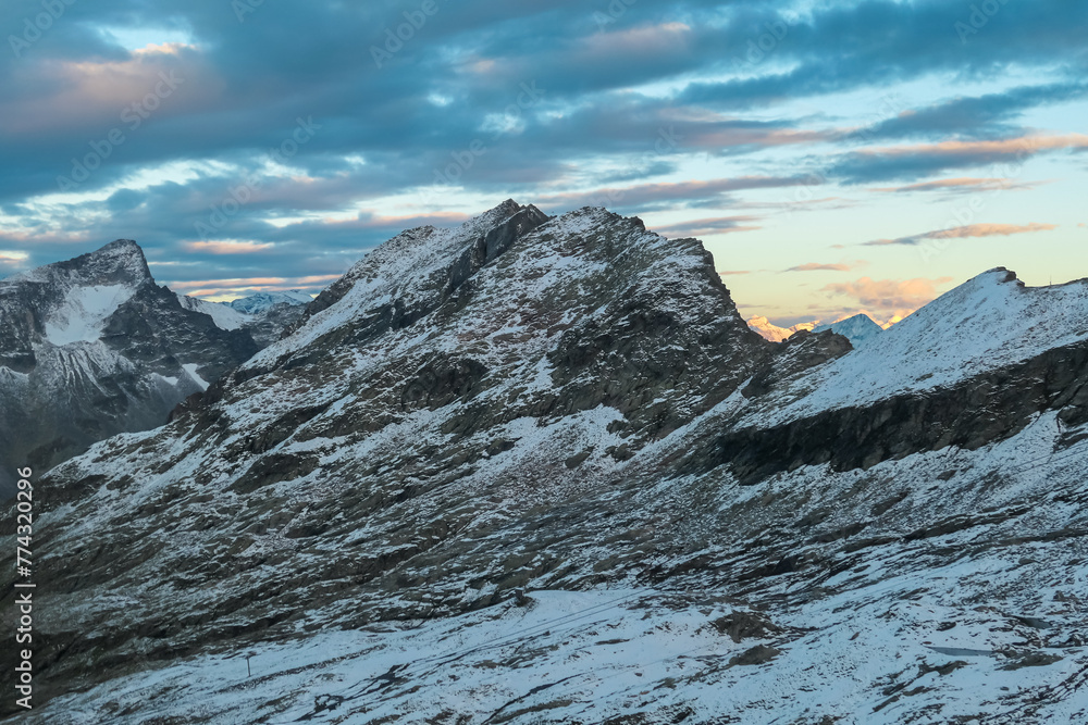Panoramic sunrise view of snow capped alpine terrain in High Tauern National Park, Carinthia, Austria. Looking at majestic Gamskalrspitz seen from Hannoverhaus. Wanderlust Austrian Alps. Nature escape