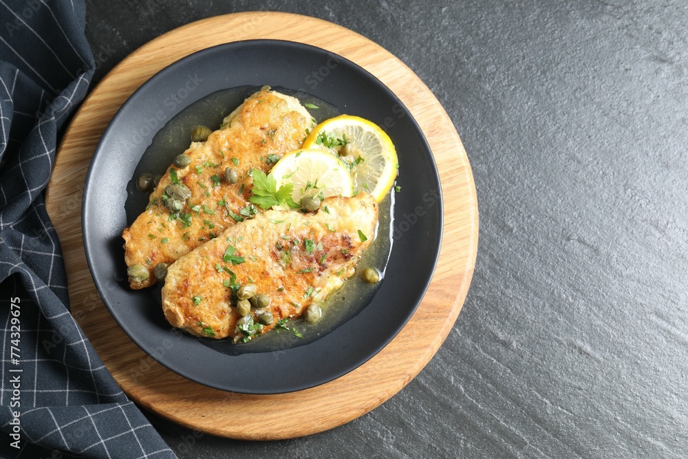 Delicious chicken piccata on black table, top view Delicious chicken piccata on black table, top view