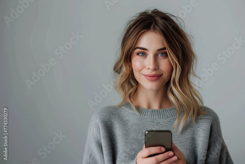 girl with a smartphone against a background of an empty wall