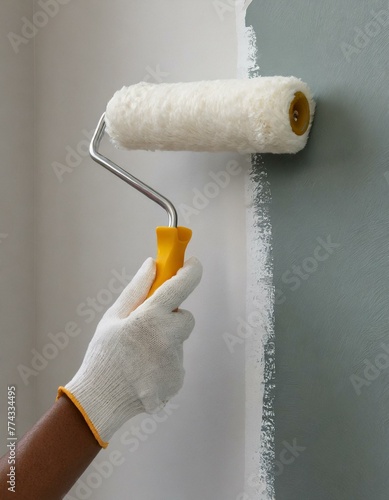 young Woman painter hand in white glove painting a room wall with paint roller