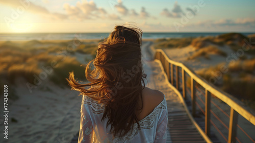 Blond girl walking in beach with blowing hair