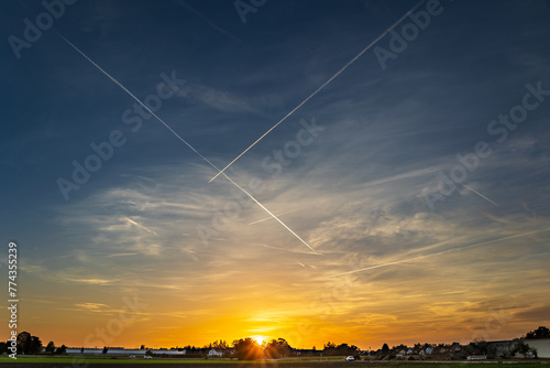 Flugverkehr im Himmel über dem Knoblauchland  mit zahlreichen kreuzenden Kondensstreifen über dem fränkischen Abendhimmel. 