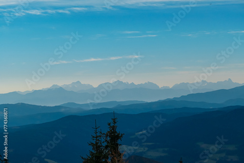 Panoramic view of magical mountain peaks of Karawanks and Julian Alps seen from Goldeck, Latschur group, Gailtal Alps, Carinthia, Austria, EU. Mystical atmosphere in Austrian Alps on sunny summer day. photo
