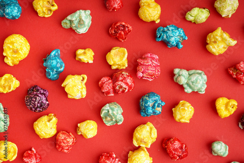 Sweet colorful popcorn on red background
