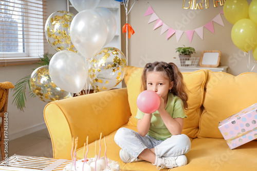 Cute little girl blowing ba...
