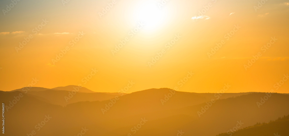 Sunset mountains panorama landscape with sunset sky and shining sun