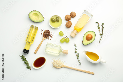 Vegetable fats. Different oils in glass bottles and ingredients on white table, flat lay