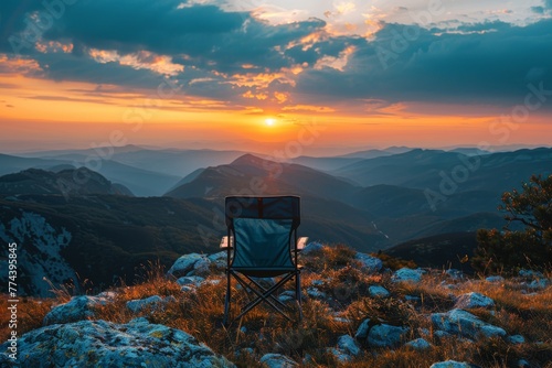 Serene mountain landscape with a single folding chair overlooking a sunset