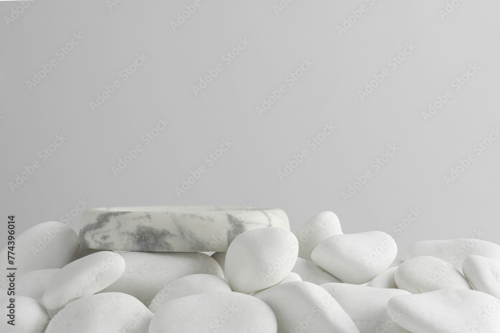 Presentation for product. Stone podium and white pebbles on light background. Space for text Presentation for product. Stone podium and white pebbles on light background. Space for text