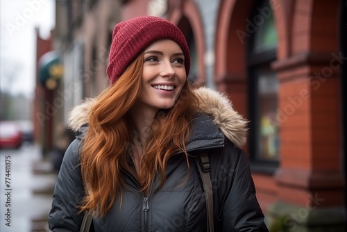 Beautiful redhead girl in a hat and jacket on the street