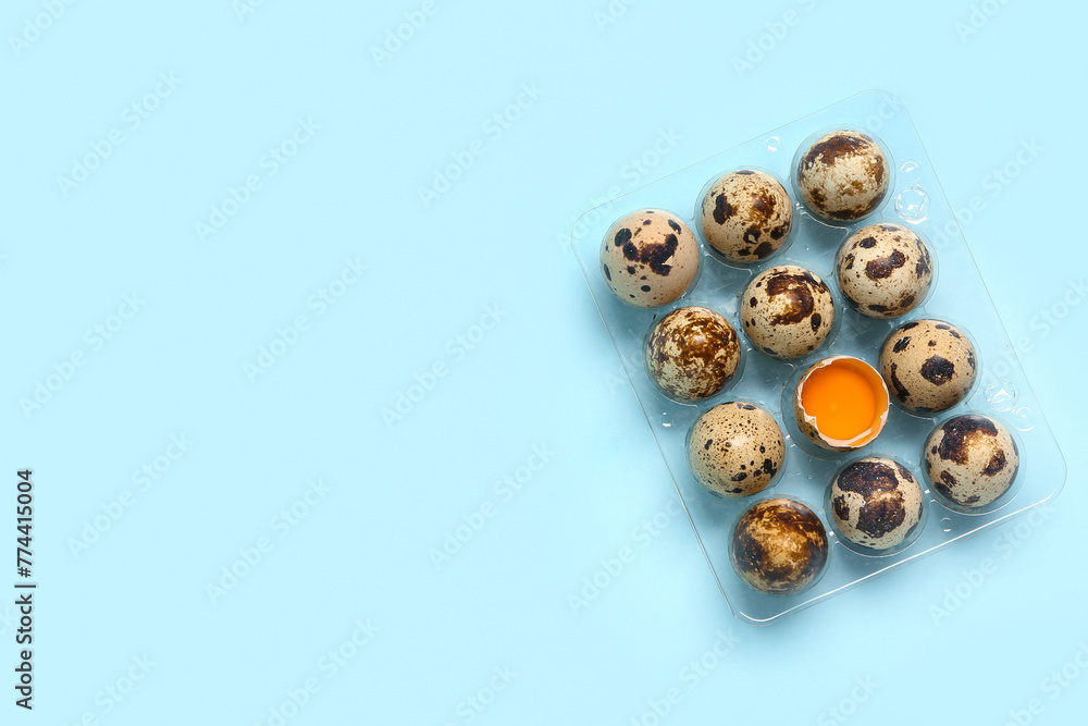 Plastic holder with fresh quail eggs on blue background Plastic holder with fresh quail eggs on blue background
