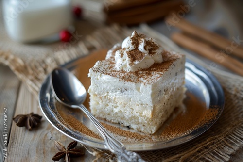 Close up of traditional Latin American tres leches cake on wooden table with spoon and cinnamon powder photo