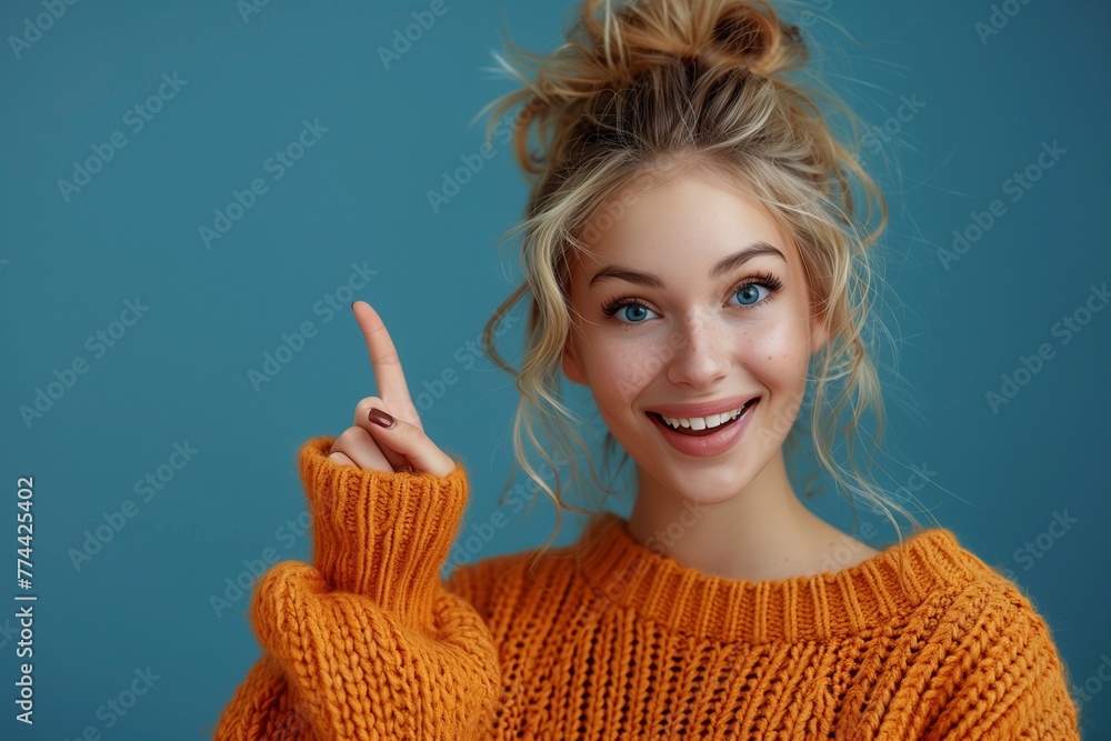 beautiful girl pointing her finger up in a orange knitted sweater beautiful girl pointing her finger up in a orange knitted sweater