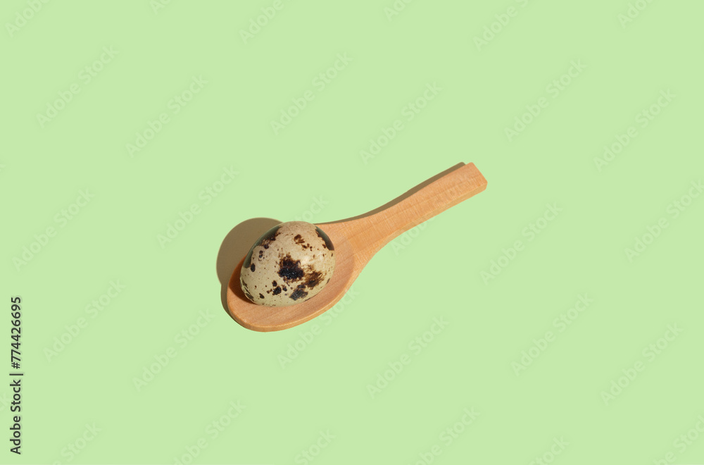 Wooden spoon with quail egg, mint background. Flat lay pattern Wooden spoon with quail egg, mint background. Flat lay pattern