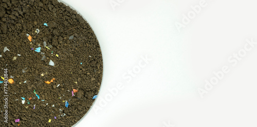 Soil sample with visible microplastics insidel. Concept of plastic pollution, fertilizing and agro industry. Non-recyclable plastic pollution in the compost at the field. Selective focus.