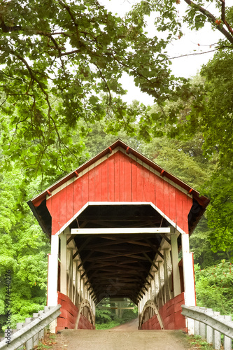 Covered bridge in summer surrounded by lush foliage