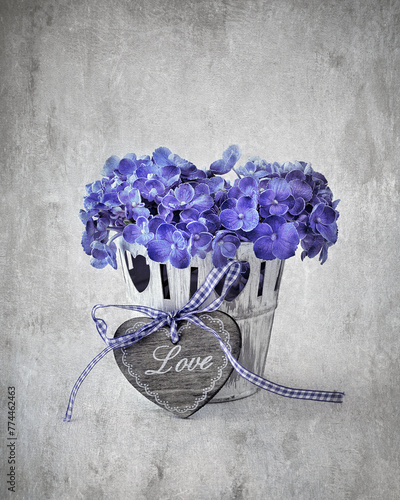 Purple hydrangea flowers and a wooden heart on a table. 