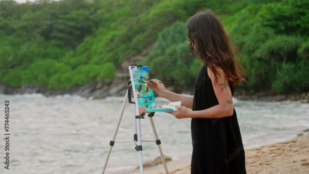 Vidéo Stock Woman paints seascape on canvas at tropical beach. Artist ...
