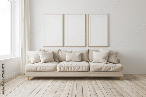 A white couch with three empty frames on the wall.