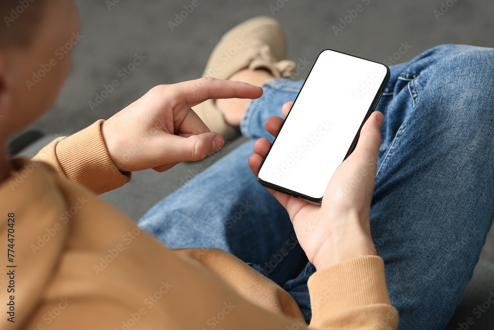 Man using smartphone with blank screen indoors, closeup. Mockup for design Man using smartphone with blank screen indoors, closeup. Mockup for design