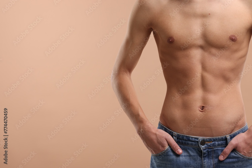 Shirtless man with slim body on beige background, closeup. Space for text Shirtless man with slim body on beige background, closeup. Space for text