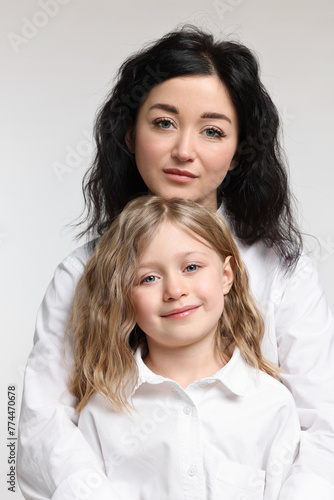 Beautiful mother with little daughter on white background