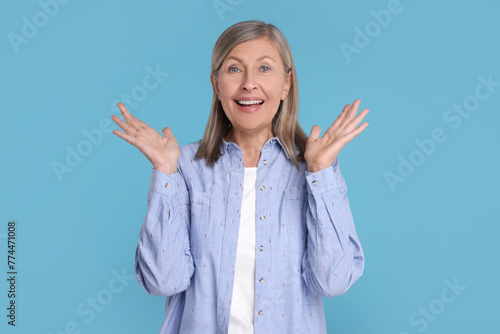 Cuadro en lienzo Portrait of happy surprised senior woman on light blue background