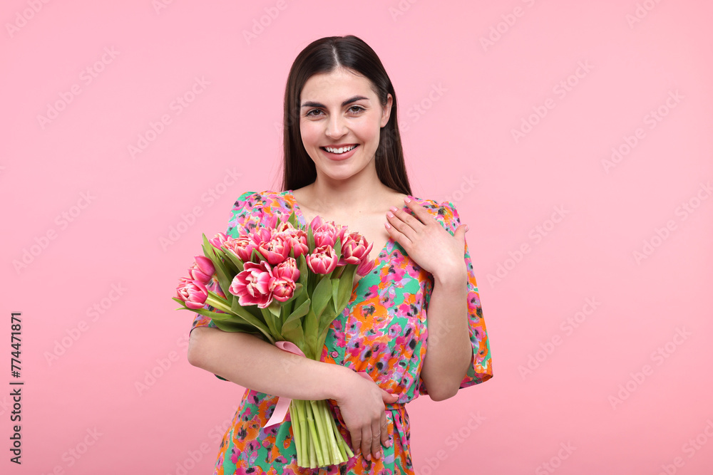 Happy young woman with beautiful bouquet on dusty pink background Happy young woman with beautiful bouquet on dusty pink background