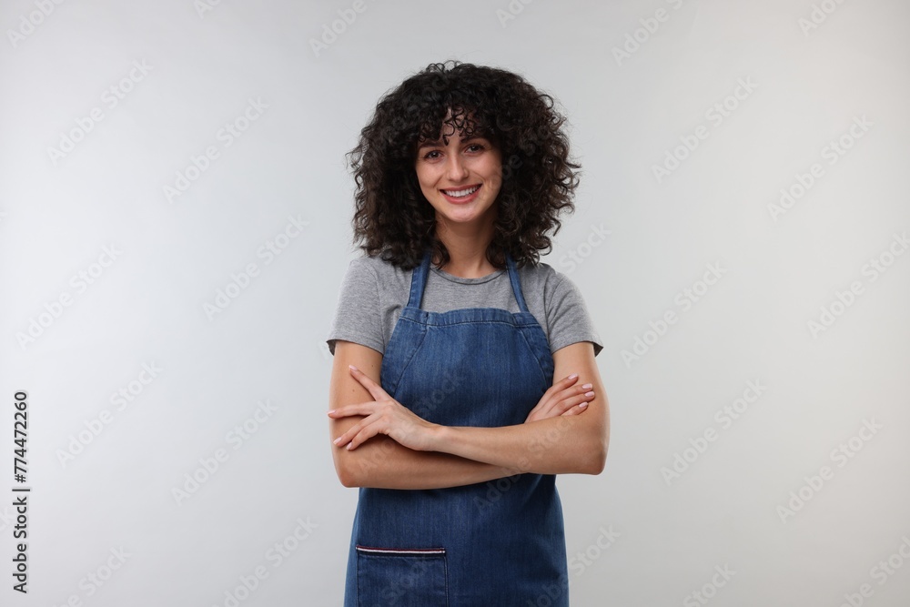 Happy woman wearing kitchen apron on light grey background. Mockup for design Happy woman wearing kitchen apron on light grey background. Mockup for design
