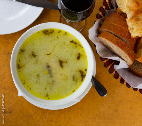 Soup chikhirtma with meat and herbs in a bowl. Chikhirtma Georgian dish photo