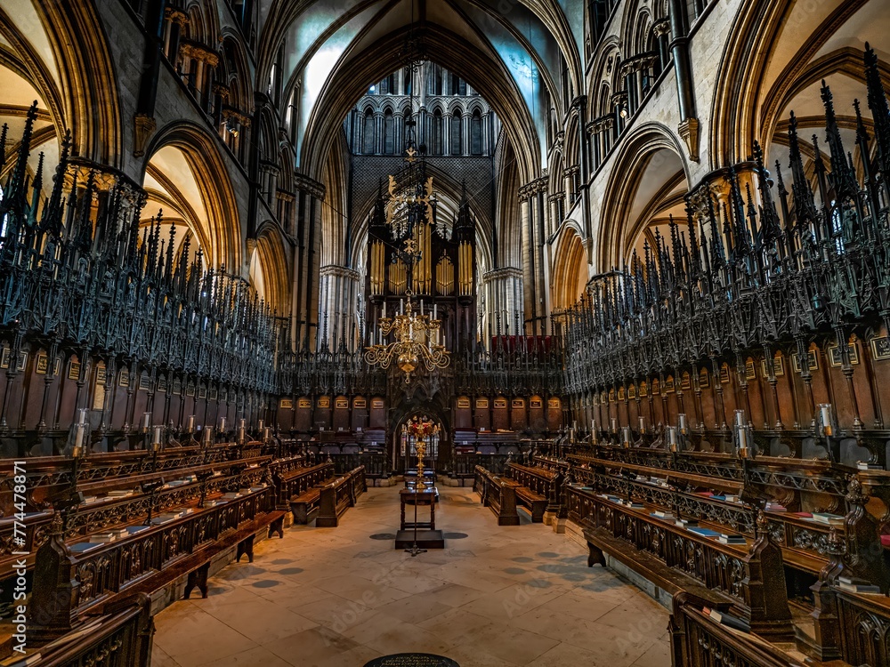 Fototapeta premium Lincoln Cathedral, Roman Catholic Gothic church and cathedral with stain glass window corridor and hall, with arches, columns, pews, vault, aisles, gallery, arcades and clerestory.
