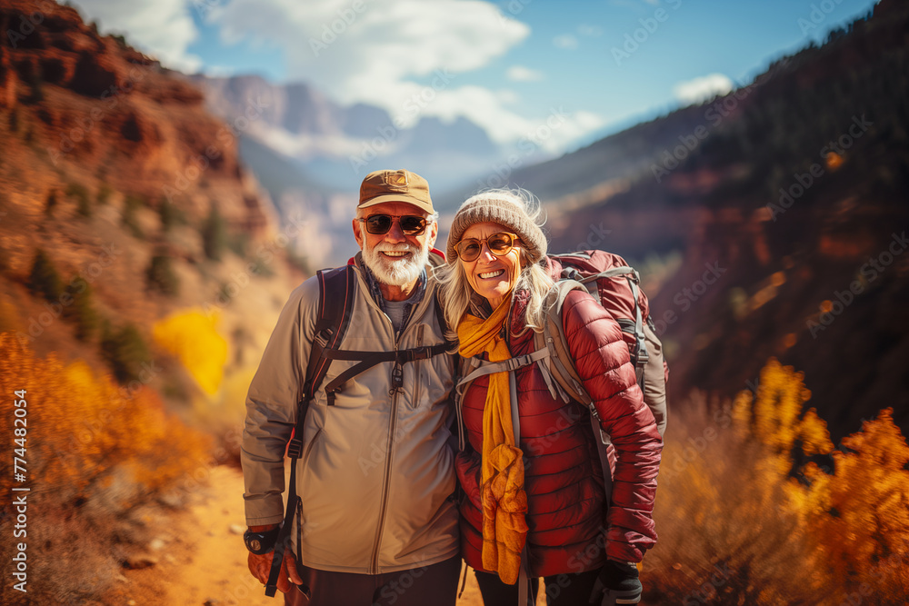 A couple of older people are posing for a picture in the mountains