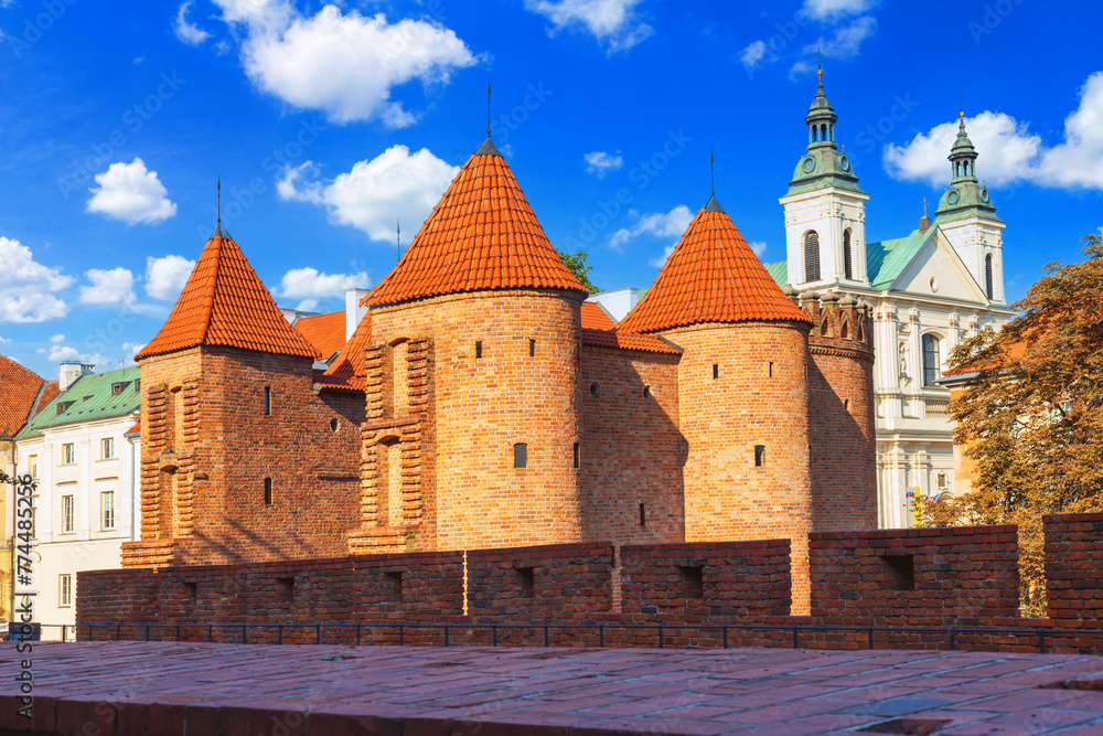 Cityscape with historic medieval fortification building Warsaw Barbican and Church of the Holy Spirit in Warsaw, Poland