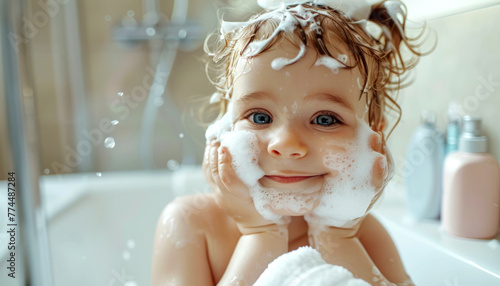 Cute smiling toddler taking a bath and applies soft foam on face in bathroom