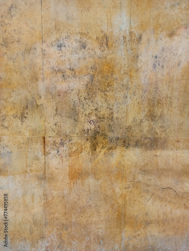 Texture of yellow marble with veins on the wall of an aged exterior facade in a city © imarginarium